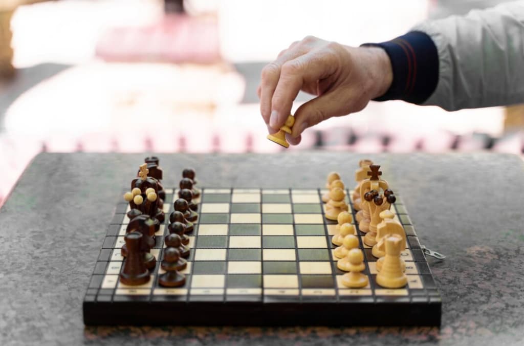 a chess board on black table and hand putting the figure