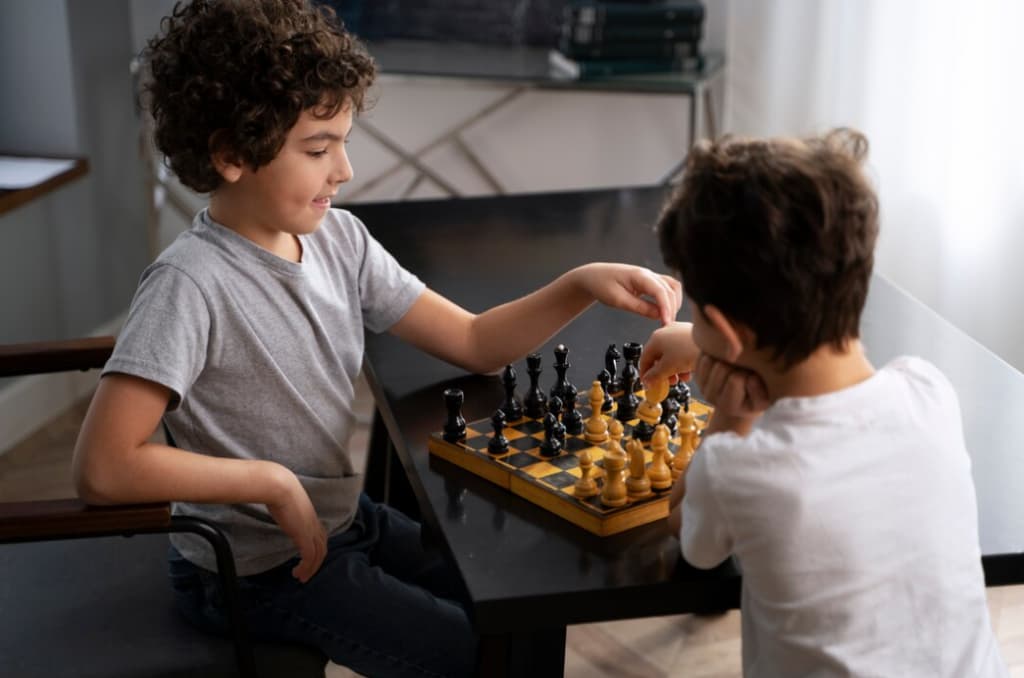 Two young boys playing chess, with one making a move on the board