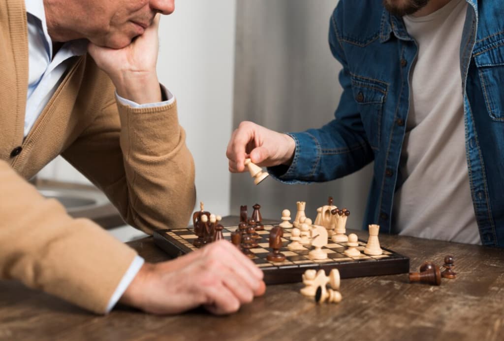 Two men engaged in a chess game, with one contemplating his next move