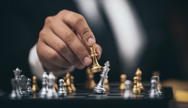 Close-up of a man making a move with a golden piece in chess