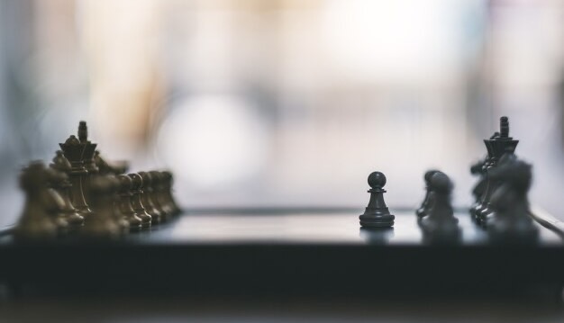 Close-up of silver and gold colored chess on a chessboard