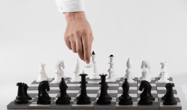 Hand with chess pieces and game board