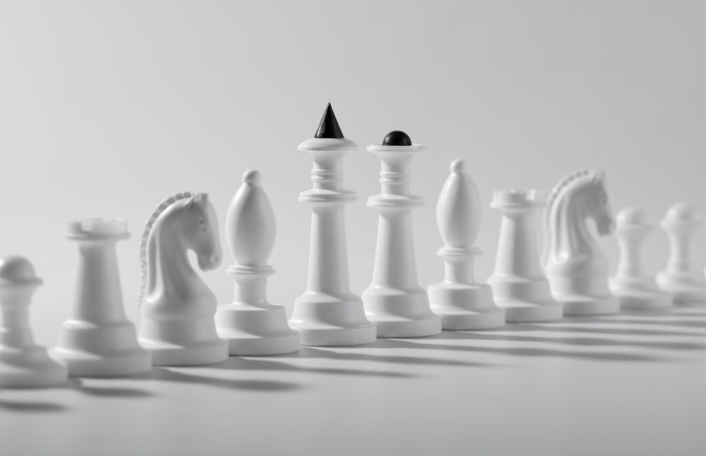 White chess pieces lined up, casting soft shadows on a pristine surface