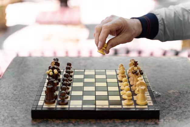 Close-up of a hand holding a chess piece